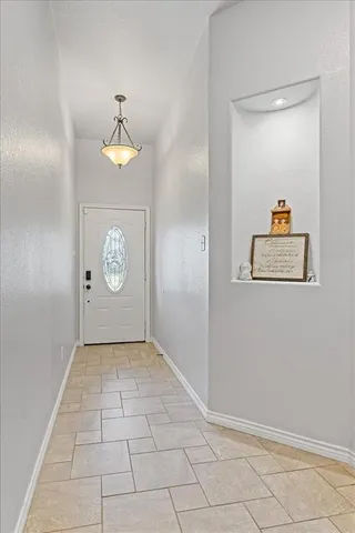 an empty room with wooden floor and hallway