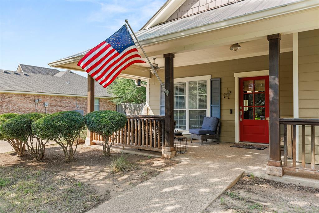 10609 Aquilla Trail Waco, TX 76708 - Photo 5 of 30 Inviting front porch featuring a vibrant red entry door, horizontal siding, and decorative shutters
