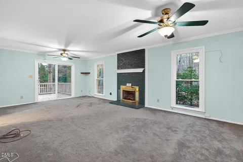 a view of an empty room with a fireplace and a window