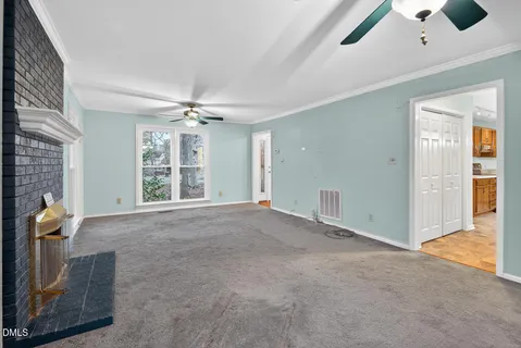 an empty room with windows and ceiling fan