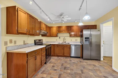 a kitchen with a sink refrigerator and cabinets