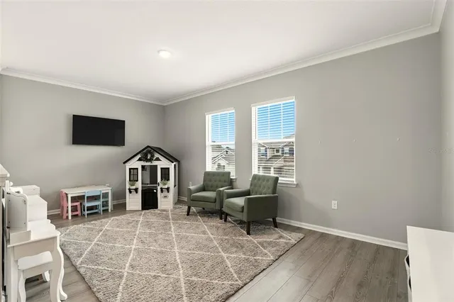 a living room with furniture a flat screen tv and a window