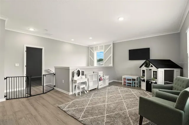a living room with furniture a flat screen tv and kitchen view