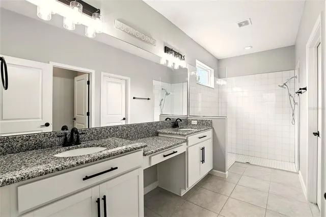 a spacious bathroom with a granite countertop sink mirror and a