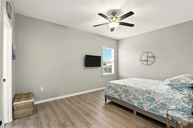a bedroom with a bed and a ceiling fan