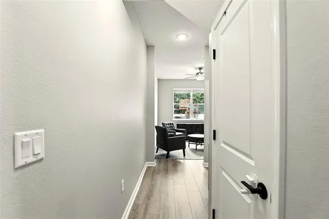 a view of a hallway to a livingroom with furniture and wooden floor