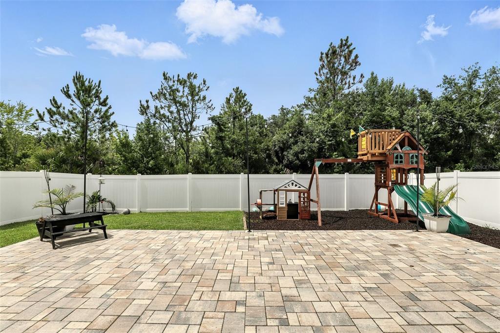 726 Porter Rye Avenue DeBary, FL 32713 - Photo 35 of 44 a swimming pool with a bench and trees in the background