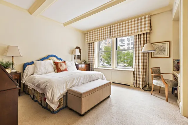 a large bed sitting in a bedroom next to a window