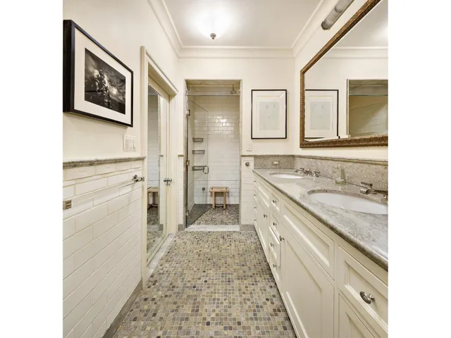 a bathroom with a granite countertop double vanity sink and a mirror