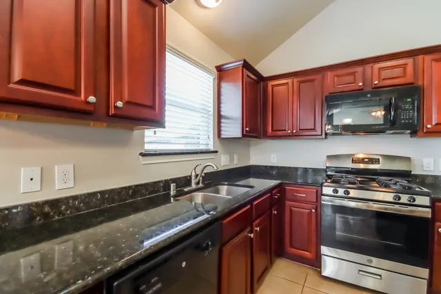 a kitchen with stainless steel appliances granite countertop a sink stove and microwave