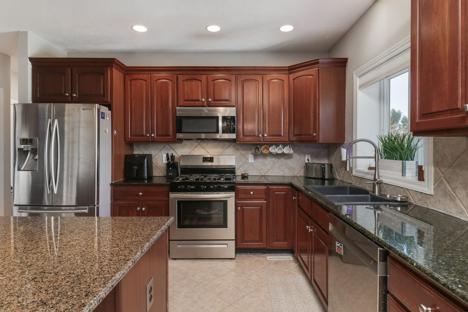 3 Pebblebrook Court Bloomington, IL 61705 - Photo 15 of 89 a kitchen with stainless steel appliances granite countertop a sink stove microwave and refrigerator