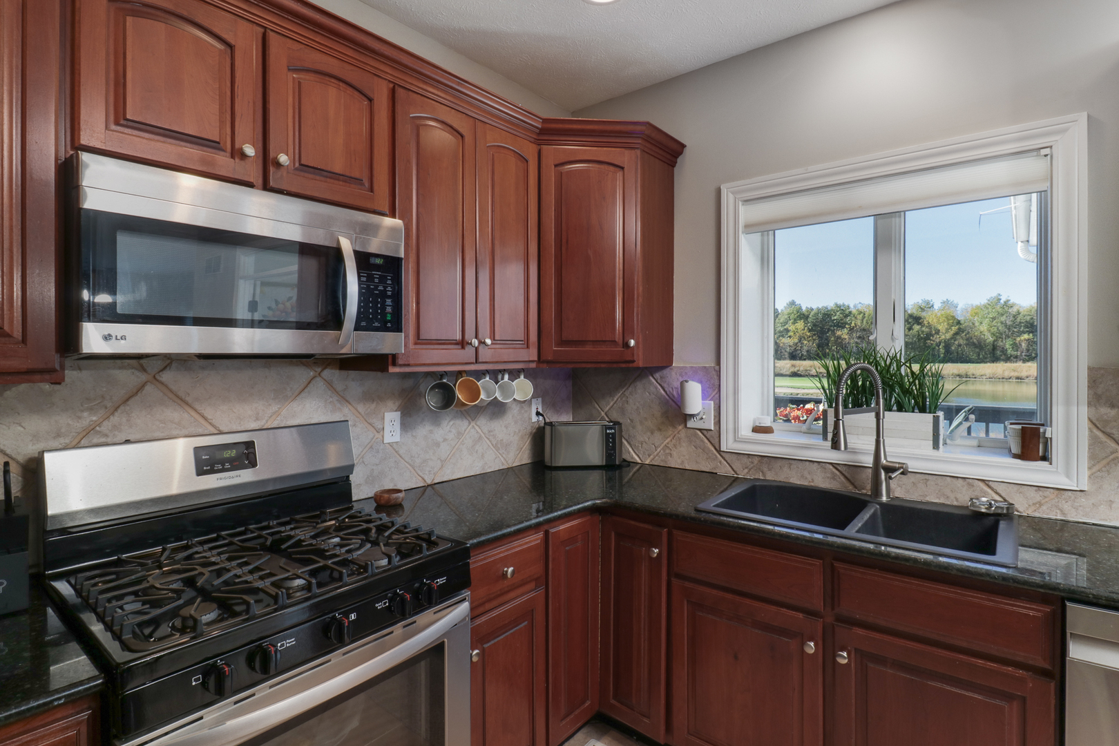 3 Pebblebrook Court Bloomington, IL 61705 - Photo 19 of 89 a kitchen with stainless steel appliances granite countertop a sink stove and microwave