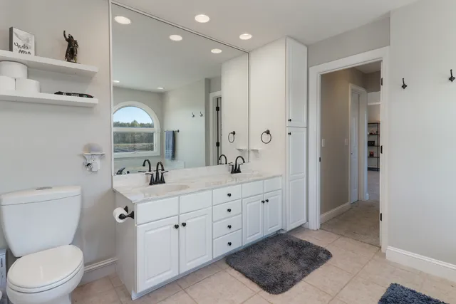 a spacious bedroom with a bed and a flat screen tv