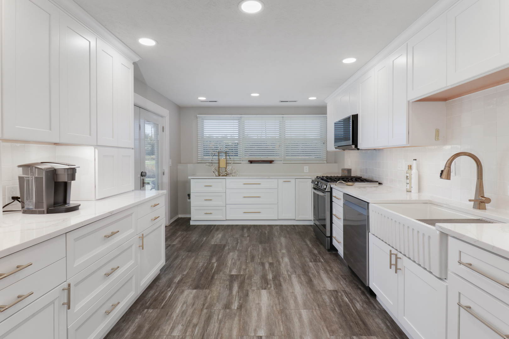 3 Pebblebrook Court Bloomington, IL 61705 - Photo 56 of 89 a kitchen with white cabinets a sink dishwasher and a stove with wooden floor