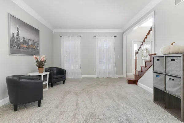 a living room with furniture and a large window with kitchen view