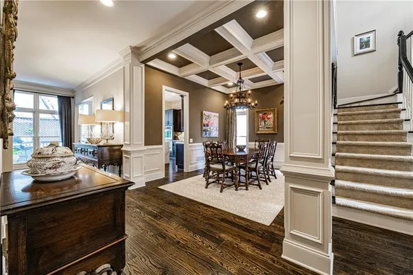 a view of a dining room and livingroom with furniture a rug a fireplace and windows