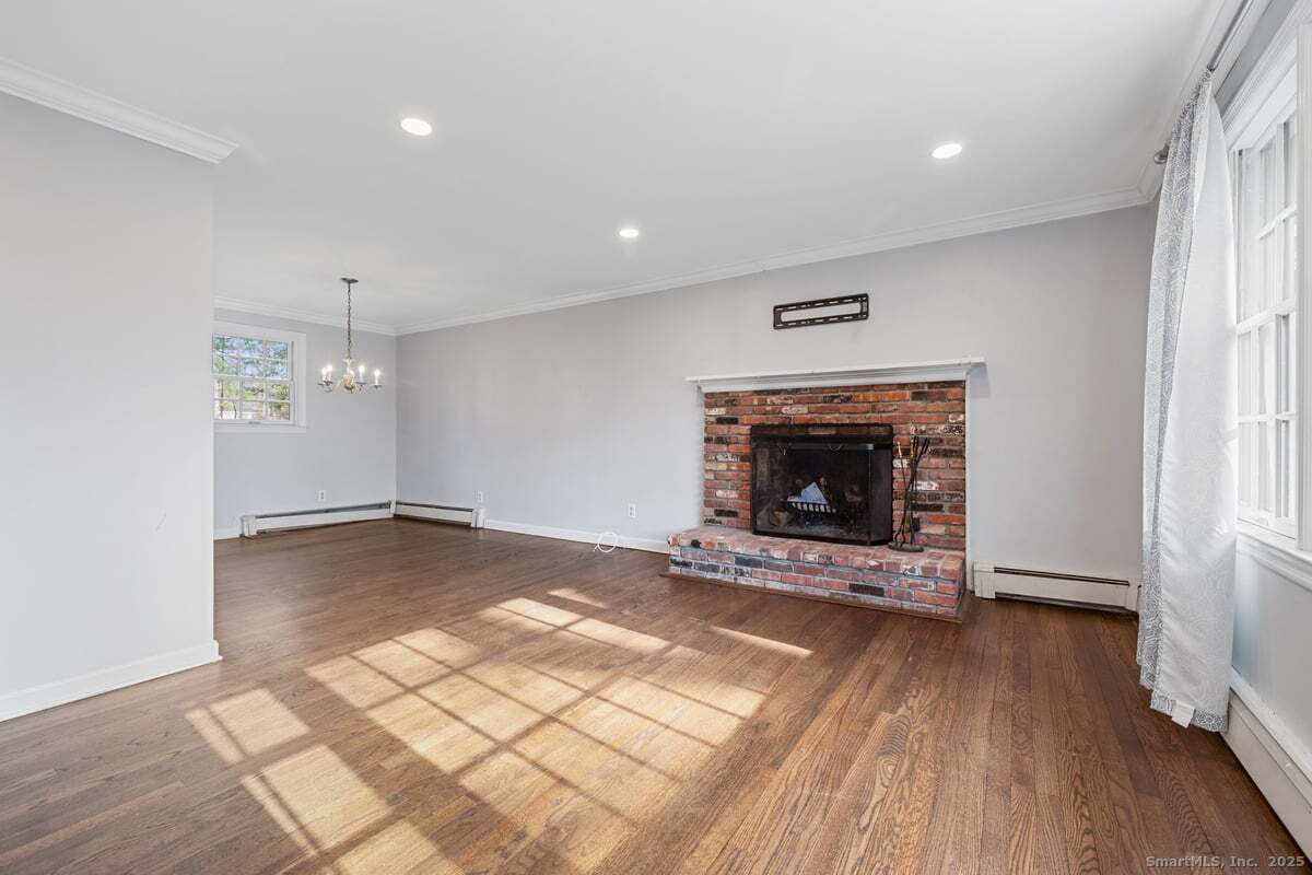 95 Ridgewood Road Ridgefield, CT 06877 - Photo 5 of 31 an empty room with wooden floor fireplace and window