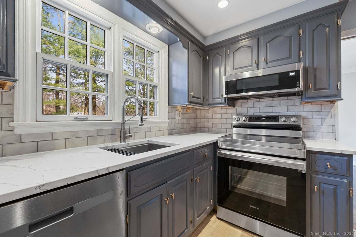 95 Ridgewood Road Ridgefield, CT 06877 - Photo 9 of 31 a kitchen with stainless steel appliances granite countertop a sink stove and microwave
