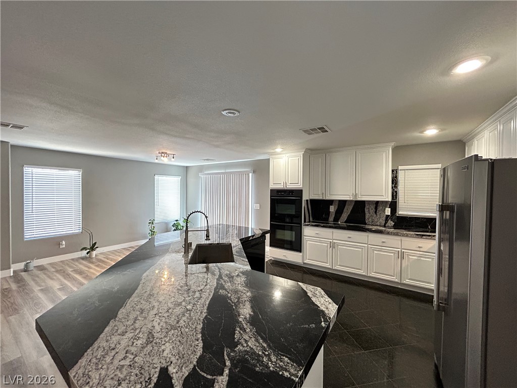 6538 Elm Spring Las Vegas, NV 89148 - Photo 5 of 29 A gourmet kitchen offers elegant granite counters and integrated appliances, flowing into an open living area.