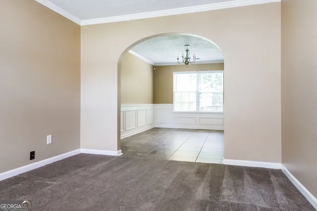 an empty room with cabinet and windows