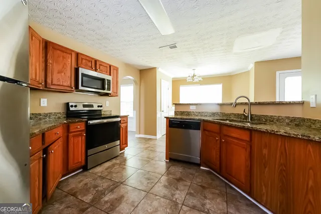 a kitchen with stainless steel appliances granite countertop a stove sink and microwave
