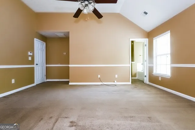 an empty room with fan and windows