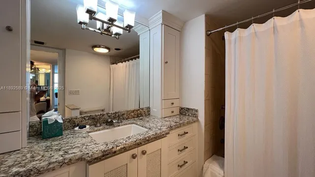 a bathroom with a granite countertop sink and a mirror