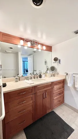 a bathroom with a granite countertop sink double vanity and mirror