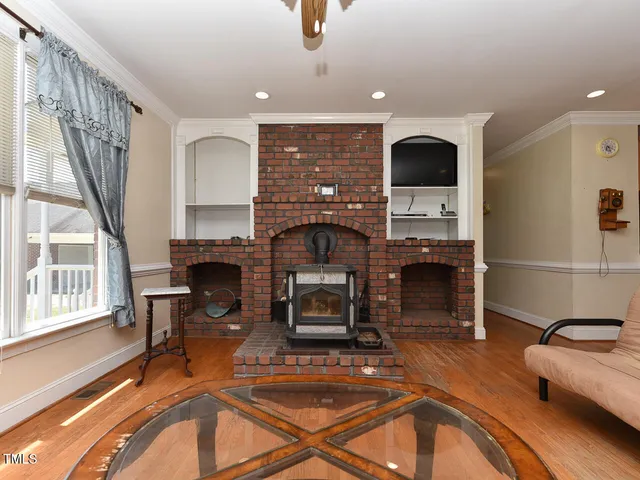 a living room with furniture a flat screen tv and kitchen view