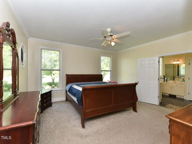 a spacious bedroom with a bed and a chandelier