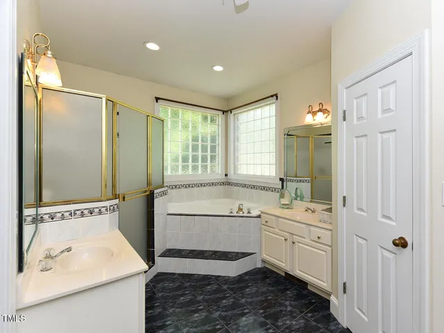 a bathroom with a tub sink and mirror