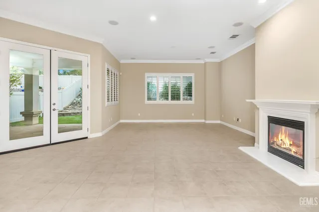 a kitchen with stainless steel appliances granite countertop a refrigerator a sink dishwasher a dining table and chairs with wooden floor