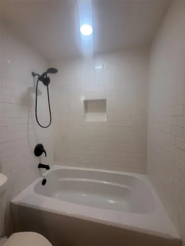 a bathroom with a bath tub with a shower