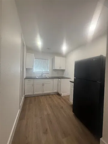 a view of a kitchen with a sink and a refrigerator