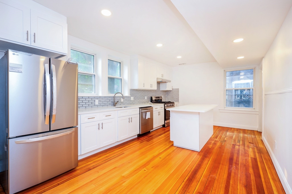 5 Chauncy Street, Unit 2 Cambridge, MA 02138 - Photo 3 of 16 a kitchen with a refrigerator and wooden floor