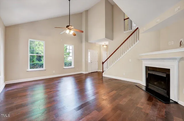 a view of an entryway with wooden floor stairs and a window