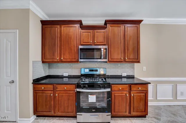 a view of an empty room with wooden floor a ceiling fan and windows