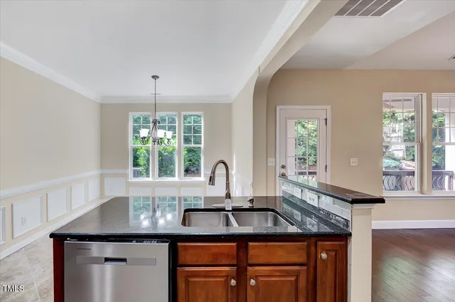 a kitchen with stainless steel appliances granite countertop a sink a stove and a refrigerator