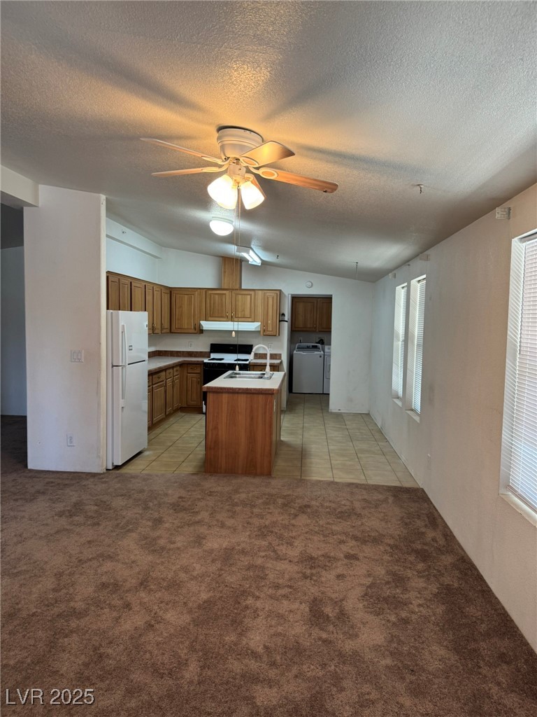 237 Piute Lane Henderson, NV 89015 - Photo 2 of 7 Kitchen with freestanding refrigerator, a ceiling fan, light colored carpet, under cabinet range hood, and a textured ceiling