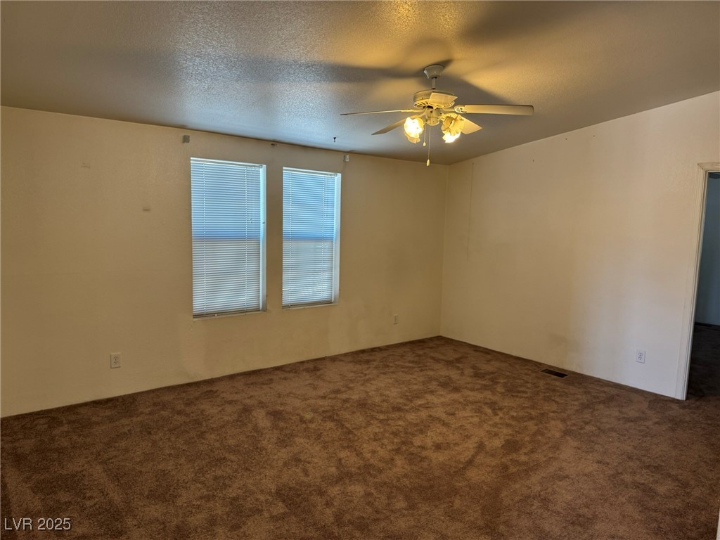 237 Piute Lane Henderson, NV 89015 - Photo 5 of 7 Carpeted spare room with ceiling fan and a textured ceiling