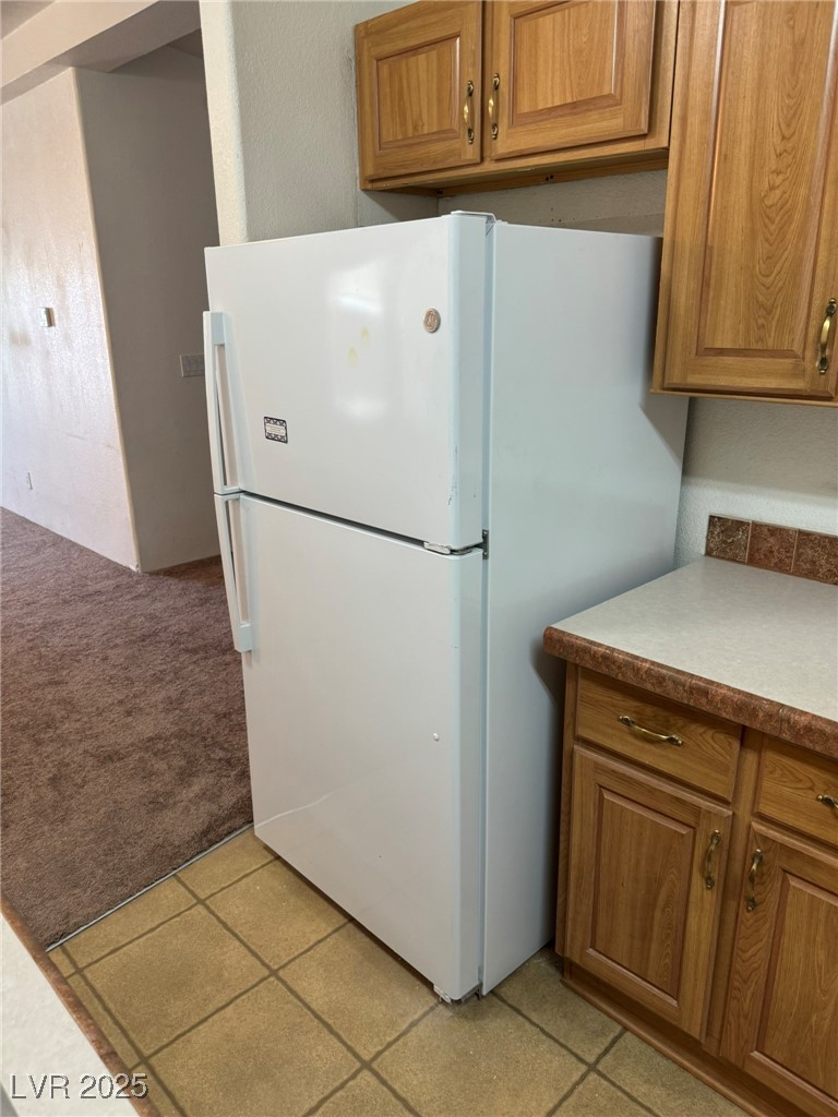 237 Piute Lane Henderson, NV 89015 - Photo 7 of 7 Kitchen featuring freestanding refrigerator, brown cabinets, and light colored carpet