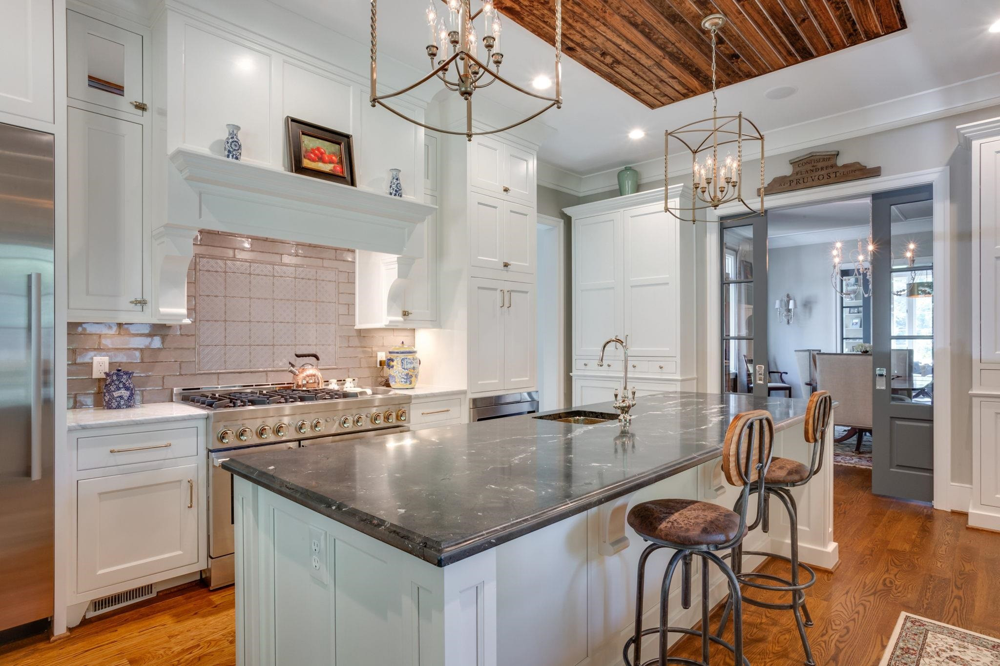 3319 Milton Road Raleigh, NC 27609 - Photo 6 of 7 a kitchen with stainless steel appliances granite countertop a stove top oven a sink dishwasher a dining table and chairs with wooden floor