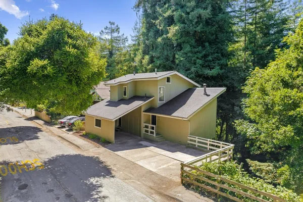 an aerial view of a house with a yard and large trees