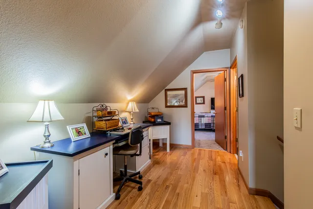 a view of a workspace with furniture and wooden floor