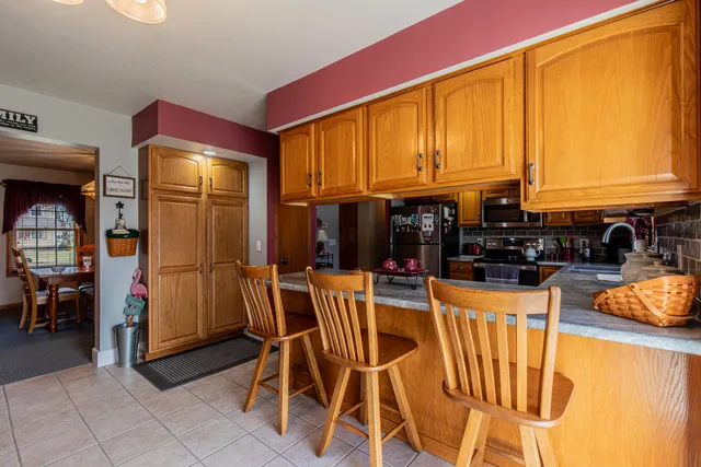 a kitchen with stainless steel appliances kitchen island granite countertop a table and chairs