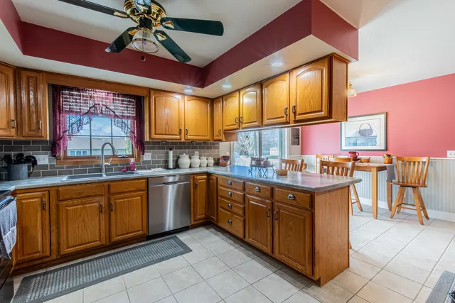 a kitchen with stainless steel appliances granite countertop wooden cabinets a sink and a large window