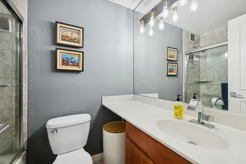 a bathroom with a sink a toilet and shower