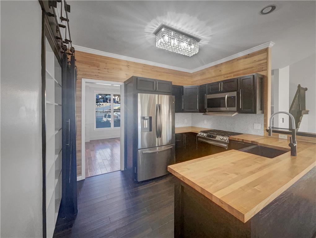 3950 Bear Ridge Place Northwest Kennesaw, GA 30144 - Photo 10 of 41 a kitchen with stainless steel appliances granite countertop a refrigerator a stove and a sink with wooden floor