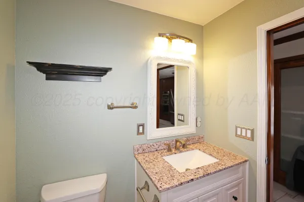 a bathroom with a granite countertop sink and a mirror