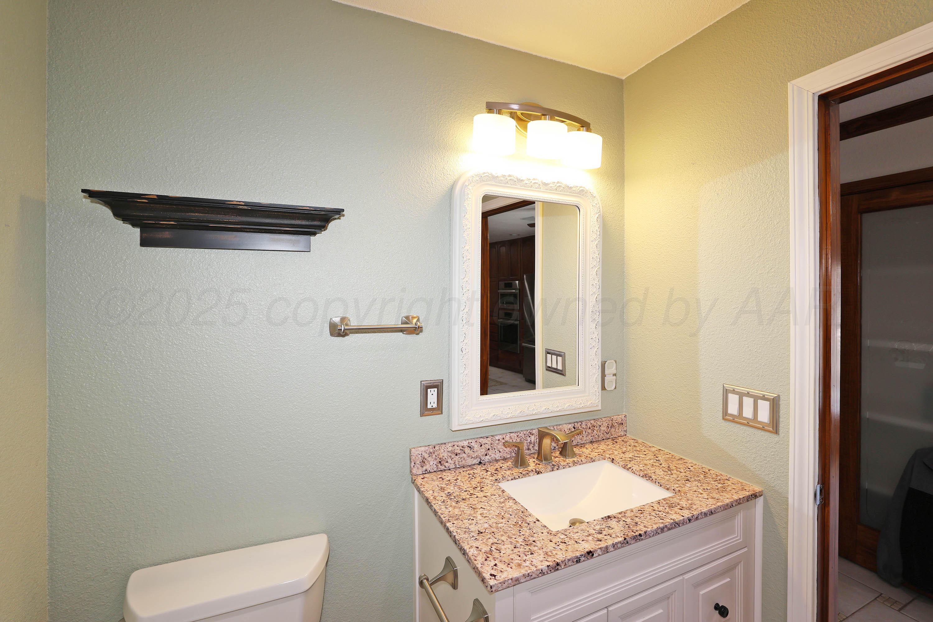 7722 Canode Drive Amarillo, TX 79121 - Photo 15 of 40 a bathroom with a granite countertop sink and a mirror
